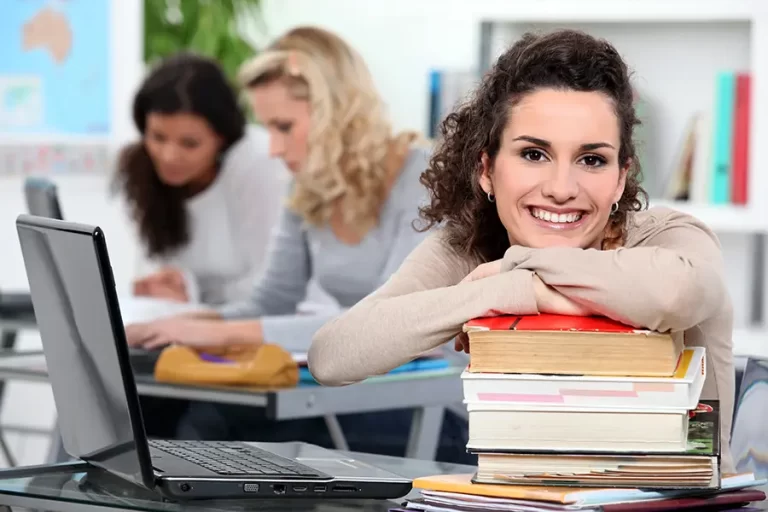 Smiling student holding books.